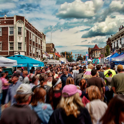 Crowded street festival showing community planning expertise.